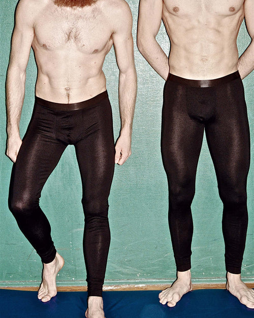Two friends posing against a wall wearing Lyocell Long Johns in Black