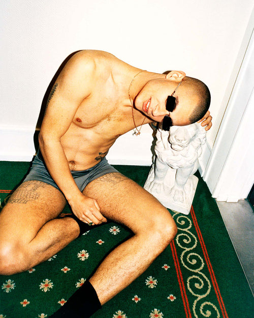 Daniel sitting on the floor wearing Lyocell Boxer Trunk in Sky Grey