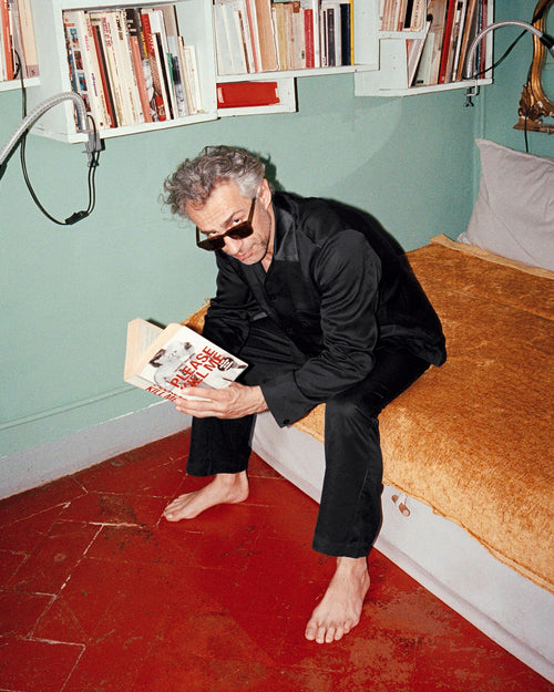 Francesco sitting in bed reading a book in Home Shirt in Black