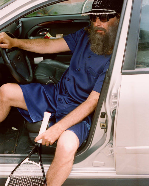 Sébastien sitting in the car wearing Home Shirt Short-Sleeve in Navy Blue