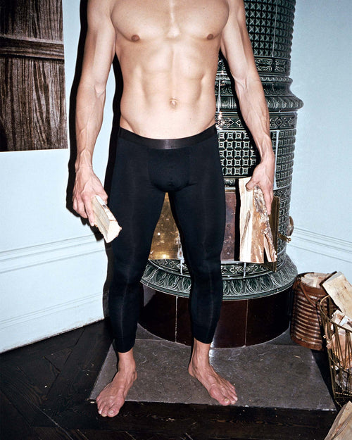 Oskar lights a fire wearing Long Johns in Black