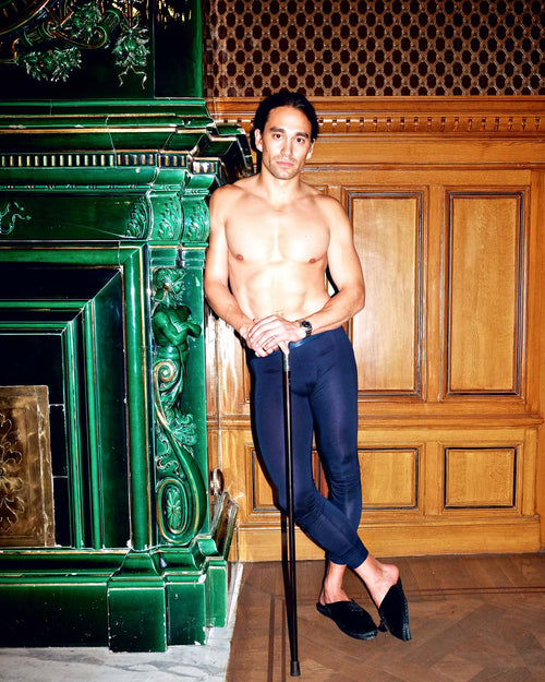 Oskar standing by the fireplace wearing Long Johns in Navy Blue