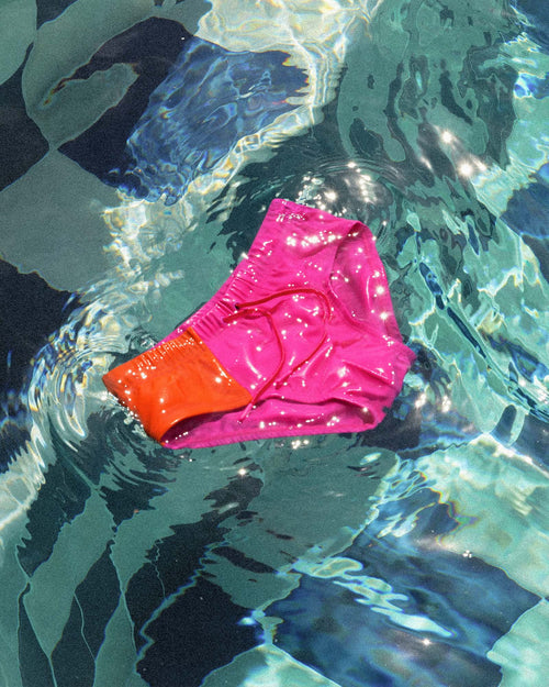 Cuixmala Swim Brief in Fuchsia / Flame floating in the pool