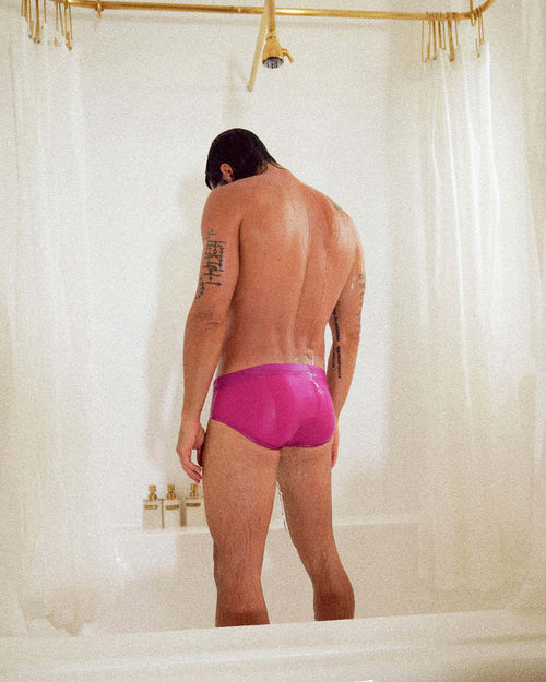 Uriel taking a shower wearing Cuixmala Swim Brief in Fuchsia / Flame